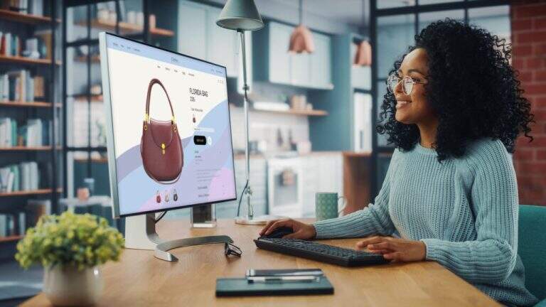 Latina Female Using Desktop Computer with Clothing Online Web Store to Choose and Buy Clothes from New Collection